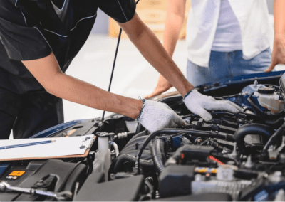 Asian male auto mechanic examine car engine breakdown problem in front of automotive vehicle