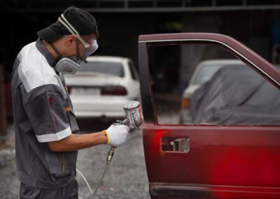 Man spraying powder paint on car door side view